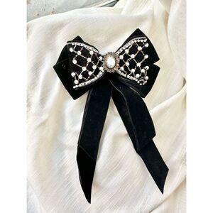 Black embellish bow with iridescent center stone ￼